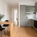 Wide shot of a modern small kitchen featuring a stylish wooden fold-down dining table and minimalist decor.