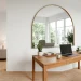 Bright modern small home office featuring a large wall mirror that creates a spacious illusion.