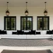 Wide horizontal view of a modern high-contrast black and white back porch with luxury furniture and decor.