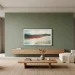 A modern living room featuring a sophisticated sage green TV wall and minimalist furniture.
