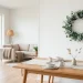 A minimalist eucalyptus wreath hangs in a bright, modern Scandinavian living room during Easter.
