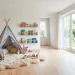 Modern Scandinavian kids room with a grey teepee reading nook and neutral decor.