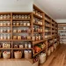 A perfectly organized walk-in kitchen pantry featuring clear bins, wooden shelves, and floor baskets.