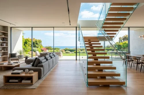 Wide view of a modern open-plan living room featuring a minimalist floating glass staircase and white oak floors.
