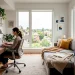 Modern tiny apartment featuring a combined home office and cozy guest room setup with a sleeper sofa