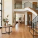 Beautiful modern foyer with oak staircase and sleek wrought iron railing blending seamlessly into a bright entryway.