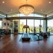 Luxurious home gym featuring an opulent crystal chandelier over sleek fitness equipment