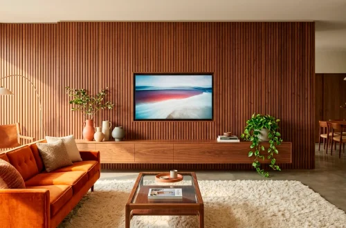 Mid-century modern living room with a stunning floor-to-ceiling slatted walnut wood TV wall setup.