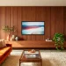 Mid-century modern living room with a stunning floor-to-ceiling slatted walnut wood TV wall setup.