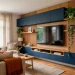 Modern multi-functional TV wall design in a small living room featuring floating navy cabinets and oak slat wood panels.