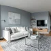 Wide view of a modern small living room decorated in cool-tone greys with a white sofa and sheer curtains