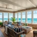 Panoramic view of an enclosed sunroom with classic shingle walls and coastal decor