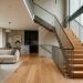 Wide panoramic view of a modern living space featuring a sleek minimalist mild steel staircase railing design.