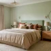 Wide horizontal banner of a beautiful sage green bedroom with elegant neutral linens and natural lighting.