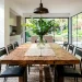 Chunky reclaimed wood dining table styled beautifully in a bright modern dining room with aesthetic decor.