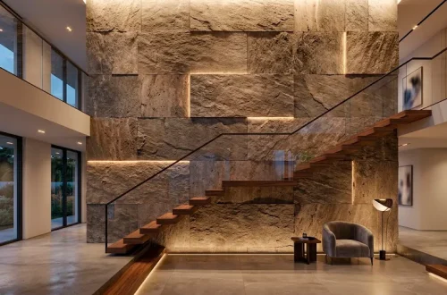 Luxurious double height staircase featuring a floor-to-ceiling textured stone wall design.