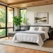 Modern guest room featuring a sleek sleeper sofa partially extended with fresh bedding in a sunny, stylish interior.