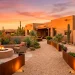 Beautiful sun-drenched Southwestern backyard landscape featuring an adobe fire pit, terracotta pots, and agave.