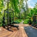 Large outdoor home gym built on a beautiful weather-resistant cedar decking platform surrounded by lush backyard trees.