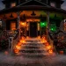 Atmospheric outdoor Halloween decoration ideas featuring a spooky glowing porch with fog and pumpkins.