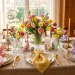 Beautifully set Easter table featuring elegantly folded pastel silk napkins on gold rimmed plates.