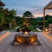Wide panoramic view of a calm Japandi outdoor patio at twilight featuring natural wood decking and minimalist furniture.