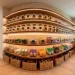 Wide view of a perfectly organized sleek modern kitchen pantry with clear bins glass jars and warm wooden floating shelves