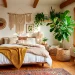 Cozy boho bedroom filled with lush statement plants like a Fiddle Leaf Fig and Monstera