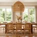 Bright boho dining room with natural rattan chairs, a mango wood table, and an oversized wicker pendant light.