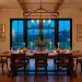 Cozy modern farmhouse dining room illuminated by a large black iron lantern chandelier over a wooden table