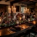 Dark cottagecore Valentine's Day decor featuring a moody dining room with wrought iron candelabras and dried black roses