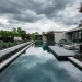 Wide landscape view of a modern patio featuring a minimalist dark slate pond with sharp geometric lines.