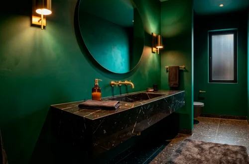 Luxurious modern powder room featuring a floating black marble vanity and emerald green walls.