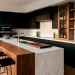 Modern minimalist kitchen with stark white marble, black cabinets, and natural walnut wood accents.