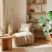 Minimalist zen reading nook with a curved chair, wooden side table, and large indoor plants bathed in soft sunlight.