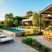 Modern weather-resistant patio furniture set on a sunny luxury backyard deck with teak and aluminum pieces.