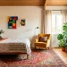 Vibrant eclectic guest room featuring a mid-century bed, bohemian rug, mustard velvet chair, and modern abstract art.