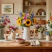 Rustic wooden dining table featuring a collection of farmhouse pitchers filled with fresh spring garden bouquets.