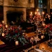 Luxurious gothic wedding table with dark velvet, glowing taper candles, and red roses