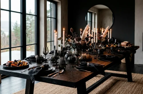 Moody Scandi-Noir Thanksgiving dining table setting with black plates and white candles