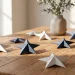 Minimalist Memorial Day paper stars arranged on a warm oak dining table in natural sunlight.