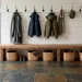 Vintage farmhouse mudroom featuring natural multicolor slate flooring, a rustic wood bench, and white shiplap walls.