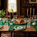 A wide view of an elegant St. Patrick's Day table setting featuring emerald greens, warm brass, and crystal glassware.