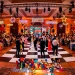 A wide view of a modern pop art wedding reception with a checkered floor and neon lights