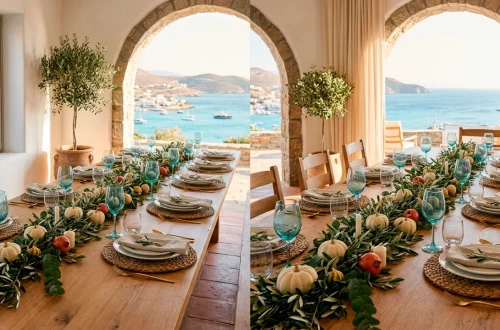 A wide view of a coastal Mediterranean Thanksgiving table with olive branches, white pumpkins, and blue glassware.
