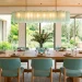 Modern dining room featuring rustic oak table, aqua chairs, and sea glass green pendant lighting.