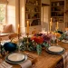 Cozy autumn interior dining table styled with colorful velvet pumpkins and brass candle holders