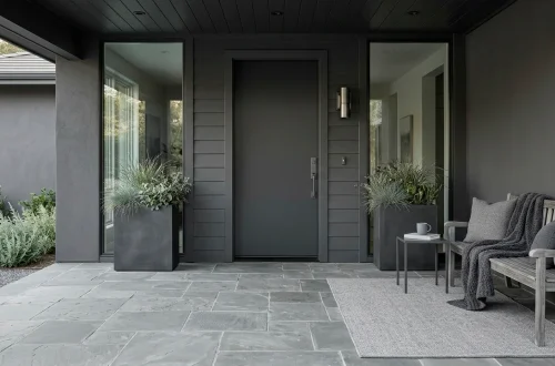 Elegant small front porch decorated in monochromatic grey tones with sleek modern planters and a cozy outdoor rug