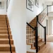 Modern refinished staircase banister featuring a sleek black wood handrail and crisp white spindles.