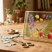 Finished botanical pressed flower frame on a sunlit wooden table for a personalized Mother's Day gift.